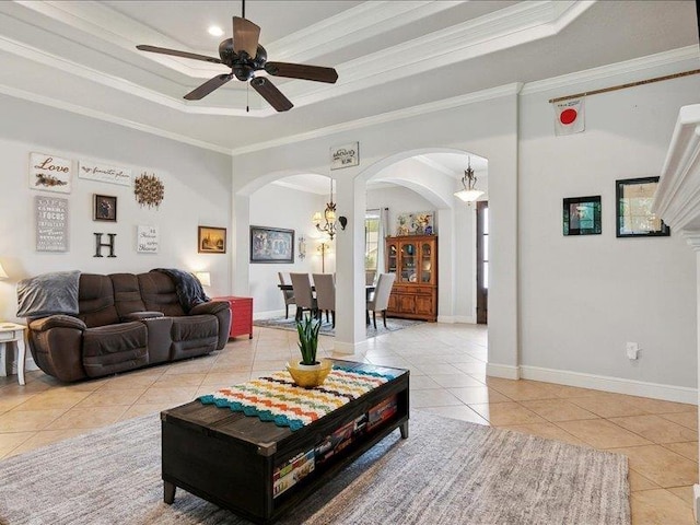 tiled living room featuring ceiling fan, crown molding, and a tray ceiling