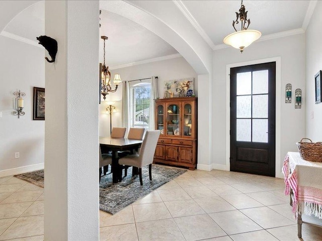 tiled entrance foyer featuring an inviting chandelier and ornamental molding