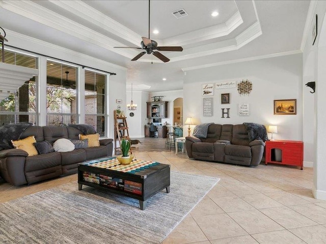 tiled living room featuring a raised ceiling, ceiling fan, and ornamental molding