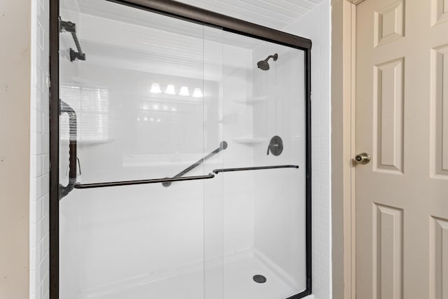 bathroom with a shower with door