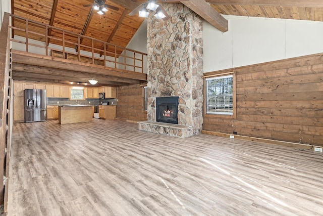 unfurnished living room featuring beam ceiling, high vaulted ceiling, and a wealth of natural light