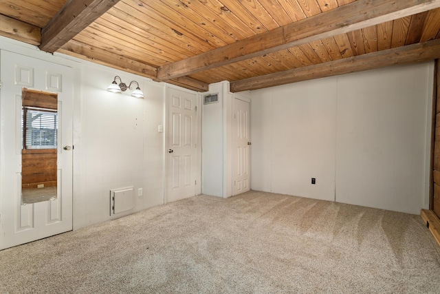 carpeted spare room with beamed ceiling and wood ceiling