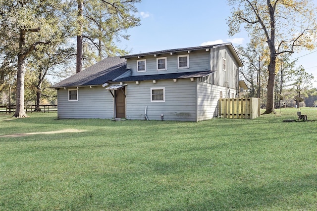 rear view of property featuring a lawn