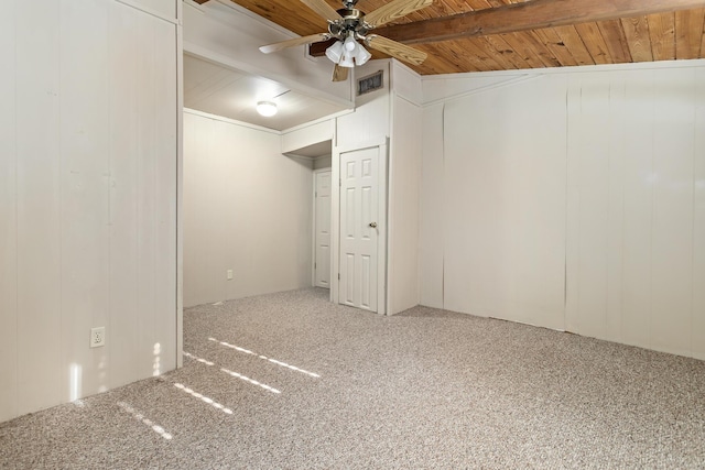 basement featuring ceiling fan, carpet floors, wooden ceiling, and wood walls