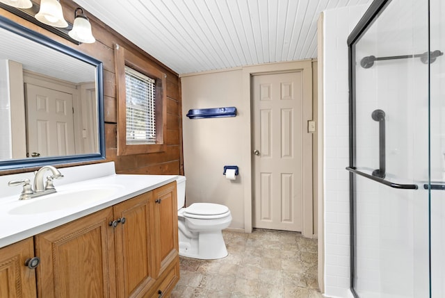 bathroom featuring a shower with door, vanity, and toilet