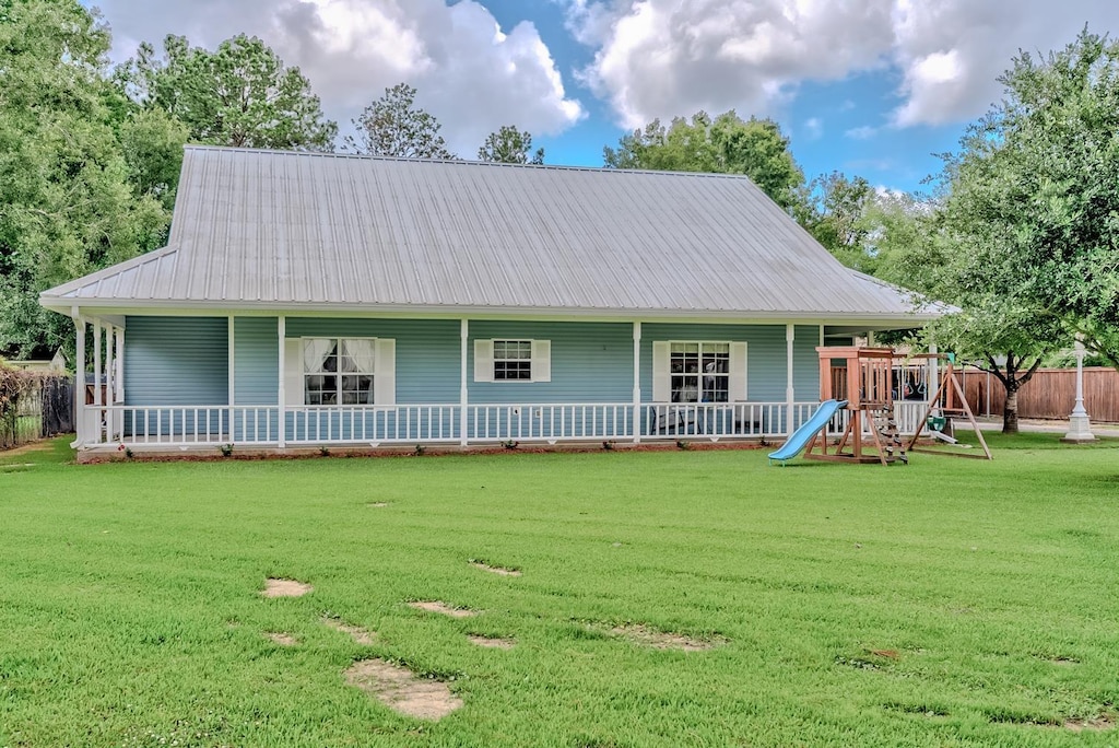 farmhouse featuring a front yard and a playground