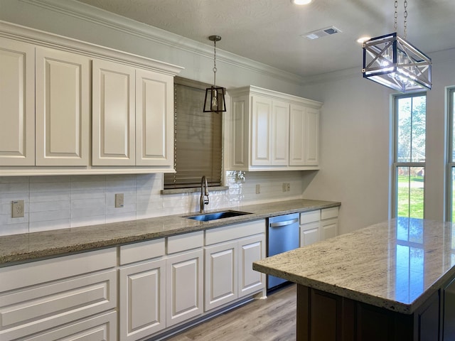 kitchen with sink, hanging light fixtures, stainless steel dishwasher, light stone countertops, and white cabinetry