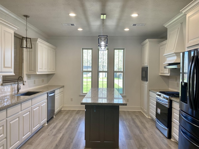 kitchen featuring white cabinets, decorative light fixtures, light stone countertops, and stainless steel appliances