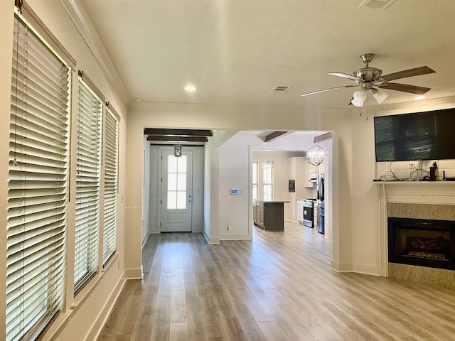 foyer entrance with ceiling fan with notable chandelier, light wood-type flooring, and ornamental molding