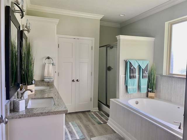 bathroom featuring vanity, hardwood / wood-style flooring, separate shower and tub, and crown molding