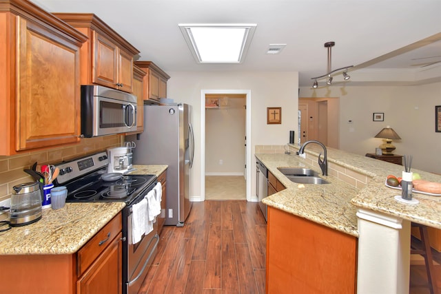 kitchen featuring light stone countertops, tasteful backsplash, stainless steel appliances, sink, and dark hardwood / wood-style floors