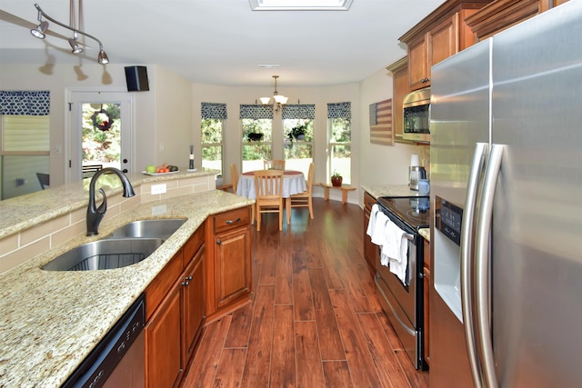 kitchen featuring pendant lighting, dark wood-type flooring, sink, a wealth of natural light, and appliances with stainless steel finishes