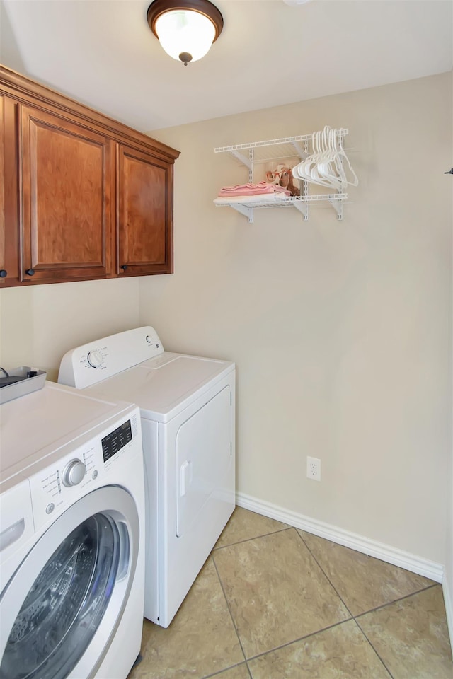 washroom featuring cabinets, independent washer and dryer, and light tile patterned floors