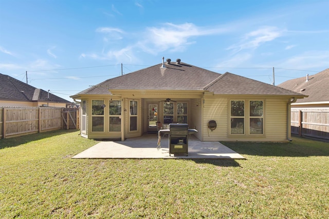 back of property with a lawn, ceiling fan, and a patio