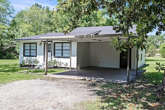 590 Parks St, Silsbee, TX 77656 - ranch-style home with roof with shingles, dirt driveway, a front yard, and a carport