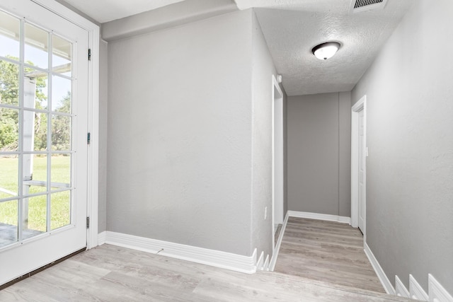 590 Parks St, Silsbee, TX 77656 - doorway to outside with a textured ceiling, baseboards, visible vents, and light wood-style floors