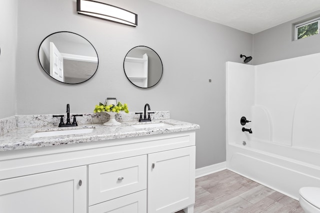 590 Parks St, Silsbee, TX 77656 - full bath featuring a sink, double vanity, bathing tub / shower combination, and wood finished floors