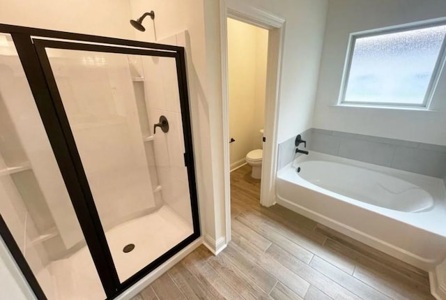 1585 Little Cypress Loop, Orange, TX 77632 - bathroom featuring a stall shower, a bath, and wood finished floors
