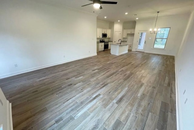 1585 Little Cypress Loop, Orange, TX 77632 - unfurnished living room featuring ceiling fan, dark wood finished floors, a chandelier, recessed lighting, and ornamental molding