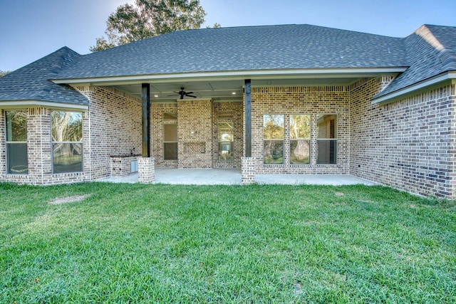 rear view of house with a patio, brick siding, ceiling fan, and a yard
