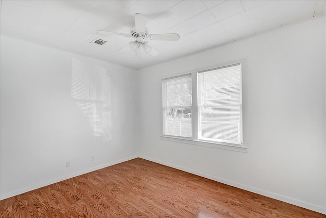 spare room featuring a wealth of natural light, ceiling fan, and light wood-type flooring