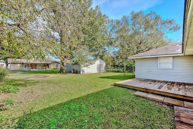 view of yard featuring a wooden deck and a storage unit