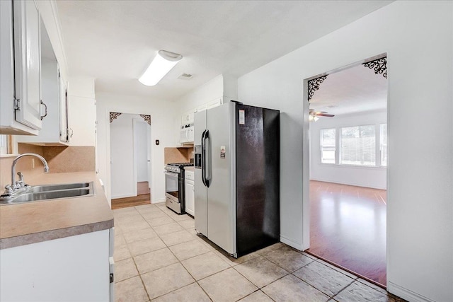 kitchen with white cabinetry, sink, ceiling fan, stainless steel appliances, and light tile patterned floors