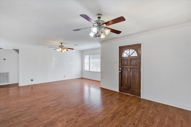 foyer featuring wood-type flooring and crown molding