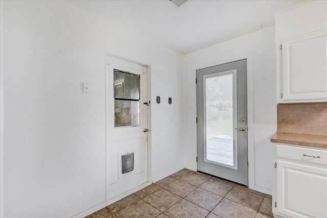 entryway with plenty of natural light and light tile patterned floors