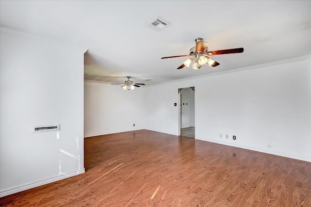 empty room with hardwood / wood-style floors and crown molding