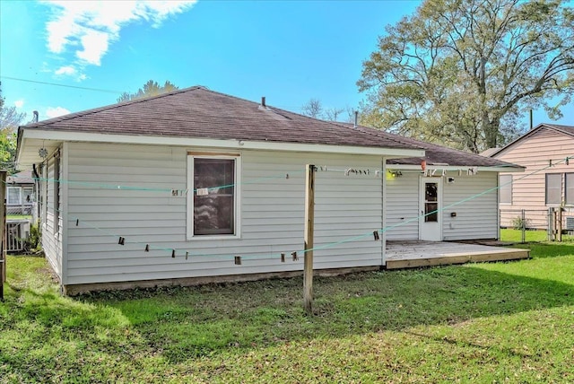 rear view of property featuring a lawn