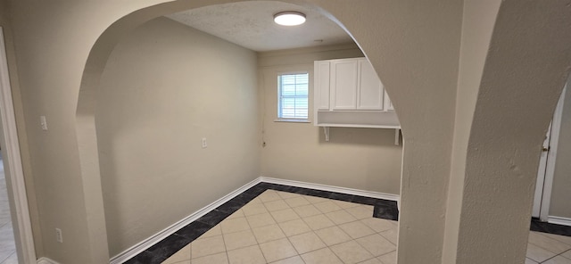 spare room with light tile patterned floors and a textured ceiling