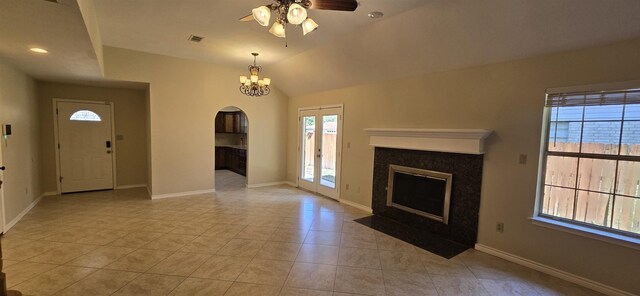 unfurnished living room featuring ceiling fan with notable chandelier, lofted ceiling, and light tile patterned flooring