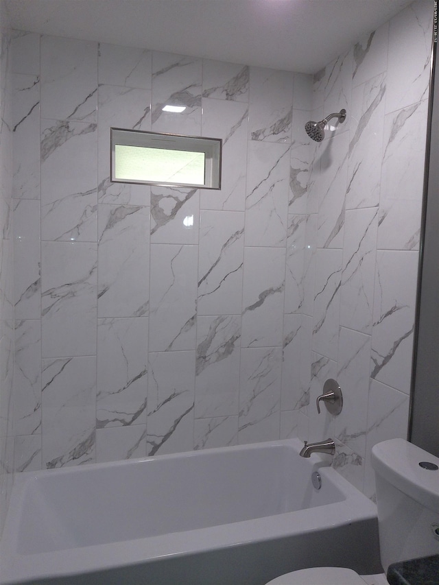 bathroom with toilet and tiled shower / bath combo