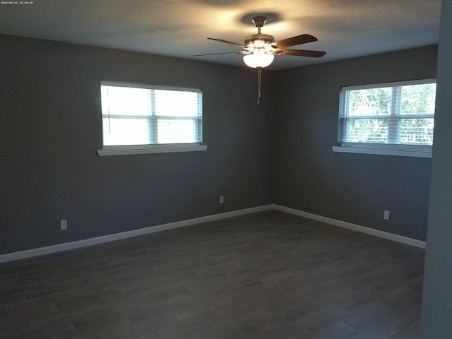 empty room with dark wood-type flooring and ceiling fan