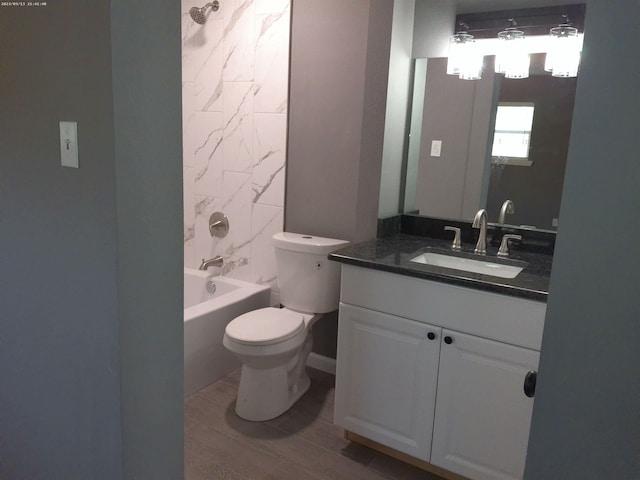 full bathroom featuring vanity, hardwood / wood-style flooring, tub / shower combination, and toilet