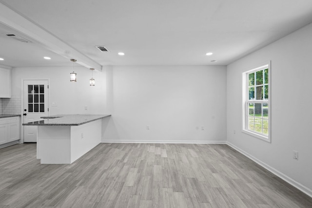 4247 Lansing Ave, Port Arthur, TX 77642 - kitchen with dark stone counters, light wood-style flooring, recessed lighting, white cabinets, and a peninsula