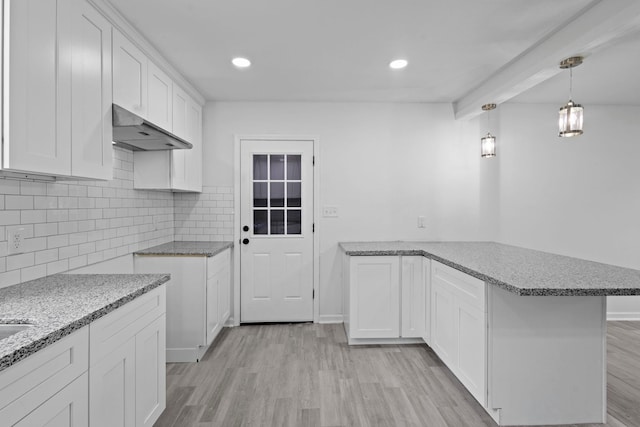 4247 Lansing Ave, Port Arthur, TX 77642 - kitchen featuring under cabinet range hood, a peninsula, light stone countertops, and recessed lighting