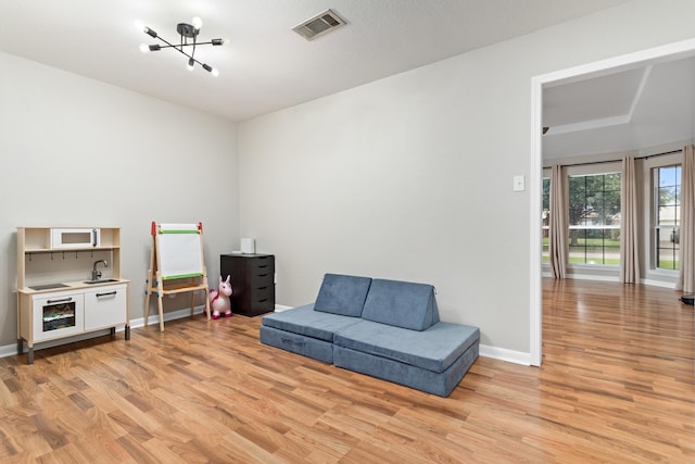 7669 Boardwalk, Lumberton, TX 77657 - living area featuring light wood-type flooring, a chandelier, and baseboards