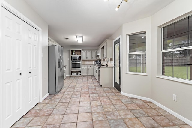 7669 Boardwalk, Lumberton, TX 77657 - kitchen with stainless steel appliances, baseboards, a sink, and gray cabinets