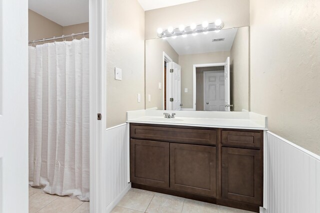 7669 Boardwalk, Lumberton, TX 77657 - bathroom with tile patterned flooring, vanity, a wainscoted wall, a decorative wall, and a shower with shower curtain