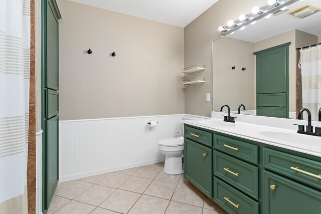 7669 Boardwalk, Lumberton, TX 77657 - full bathroom with wainscoting, double vanity, tile patterned floors, toilet, and curtained shower