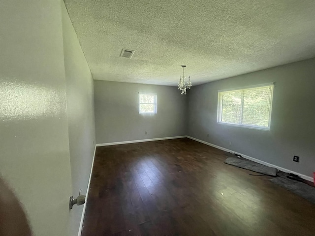 775 Todd St, Beaumont, TX 77707 - empty room featuring dark wood-style flooring, a chandelier, and a textured ceiling