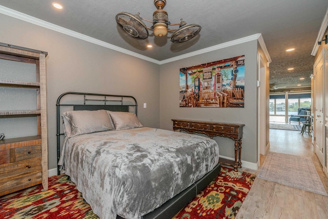 bedroom featuring ceiling fan, light hardwood / wood-style floors, and crown molding