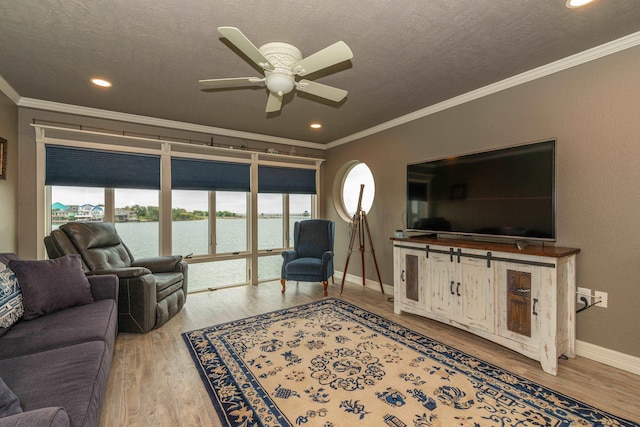 living room with crown molding, ceiling fan, a textured ceiling, and hardwood / wood-style flooring