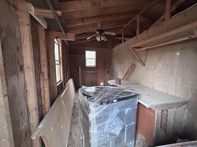 miscellaneous room featuring lofted ceiling, ceiling fan, and wood walls