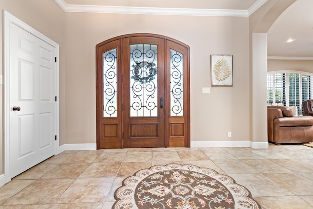 tiled entrance foyer with crown molding and french doors