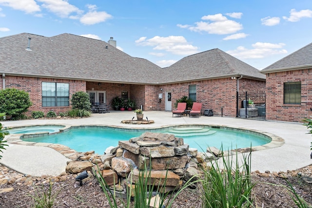 view of pool with an in ground hot tub, a patio, and french doors