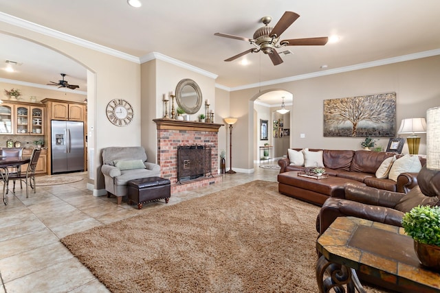 living room featuring crown molding, a fireplace, and ceiling fan