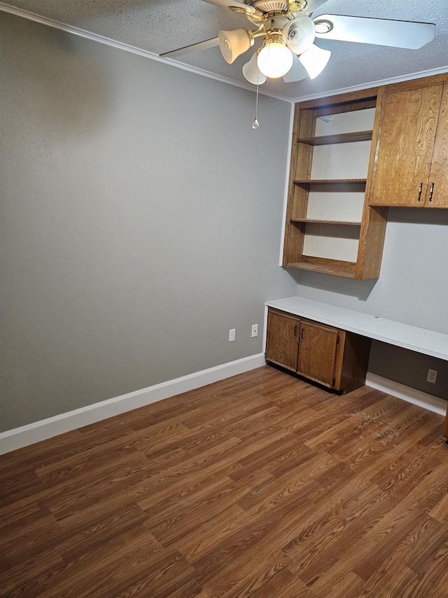 unfurnished office with ceiling fan, dark hardwood / wood-style flooring, and crown molding